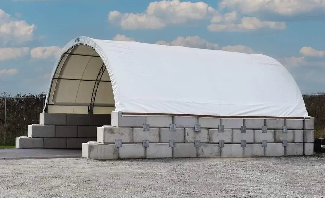 A white tent is sitting on top of a pile of bricks.