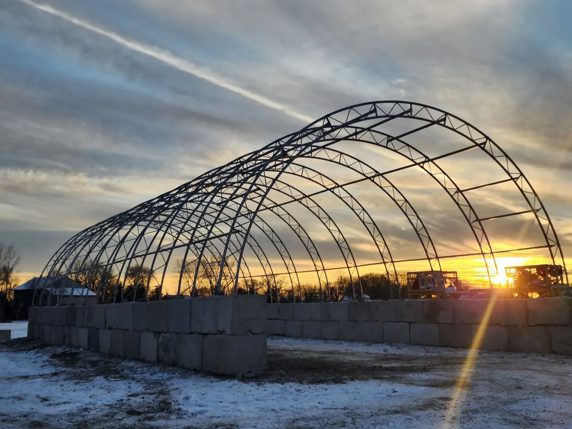 A large metal structure with a sunset in the background