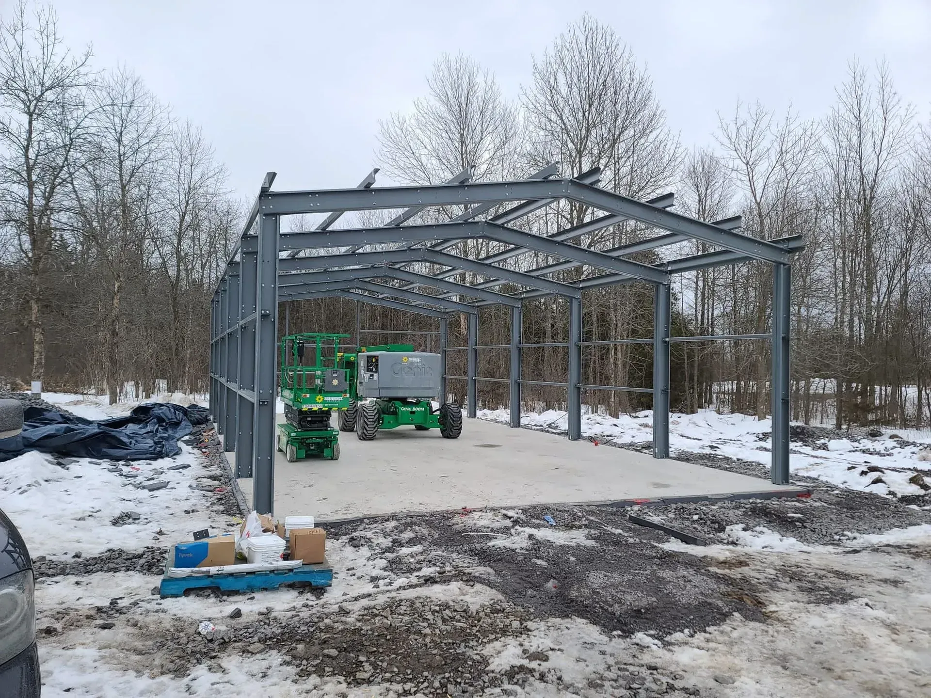 A large metal structure is being built in the snow.