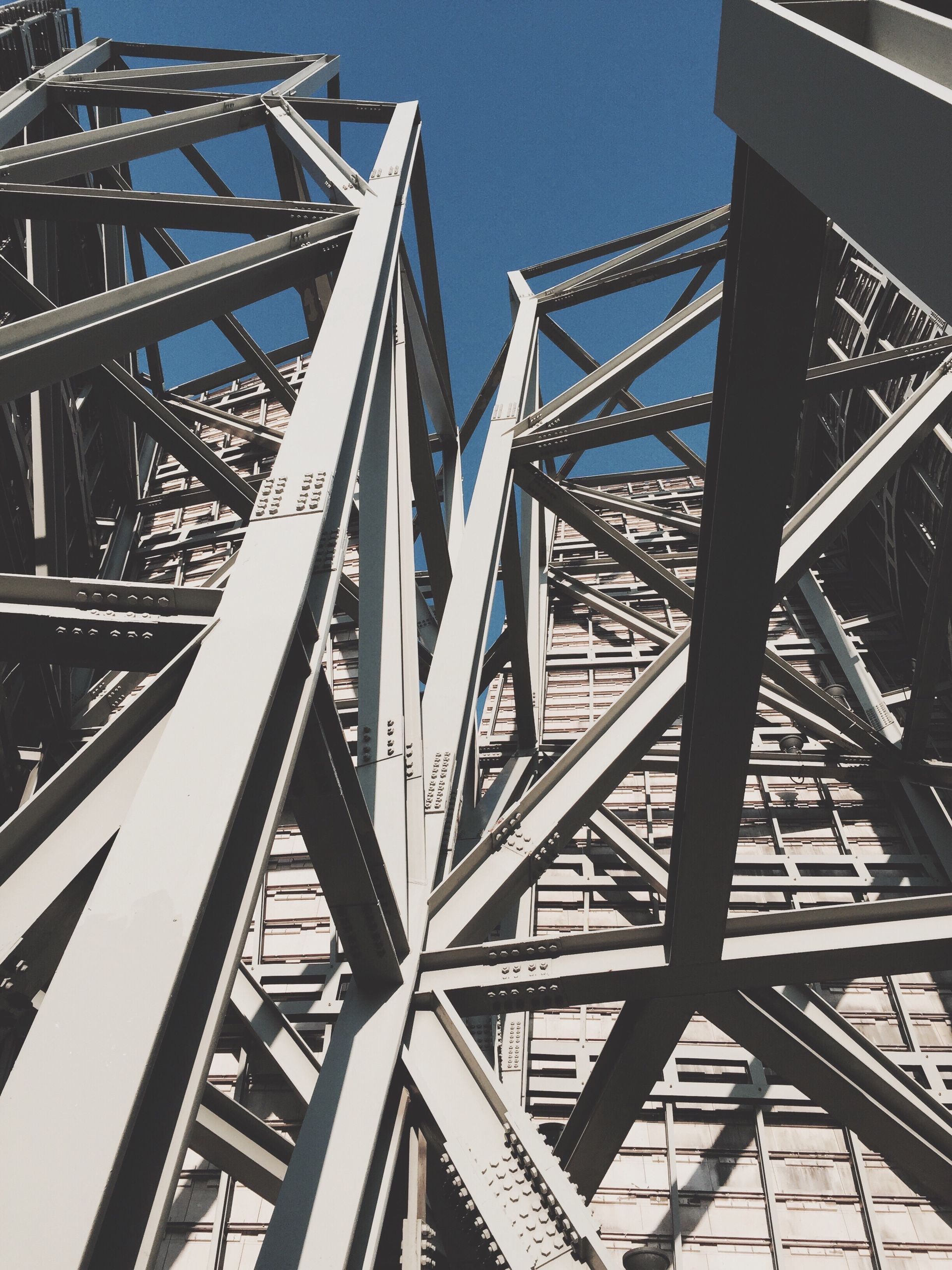 Looking up at a metal structure with a blue sky in the background