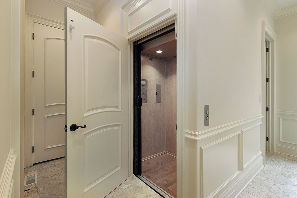 An Elevator Is Sitting in A Hallway Next to A Door — Master Lifts Cairns in Cairns, QLD