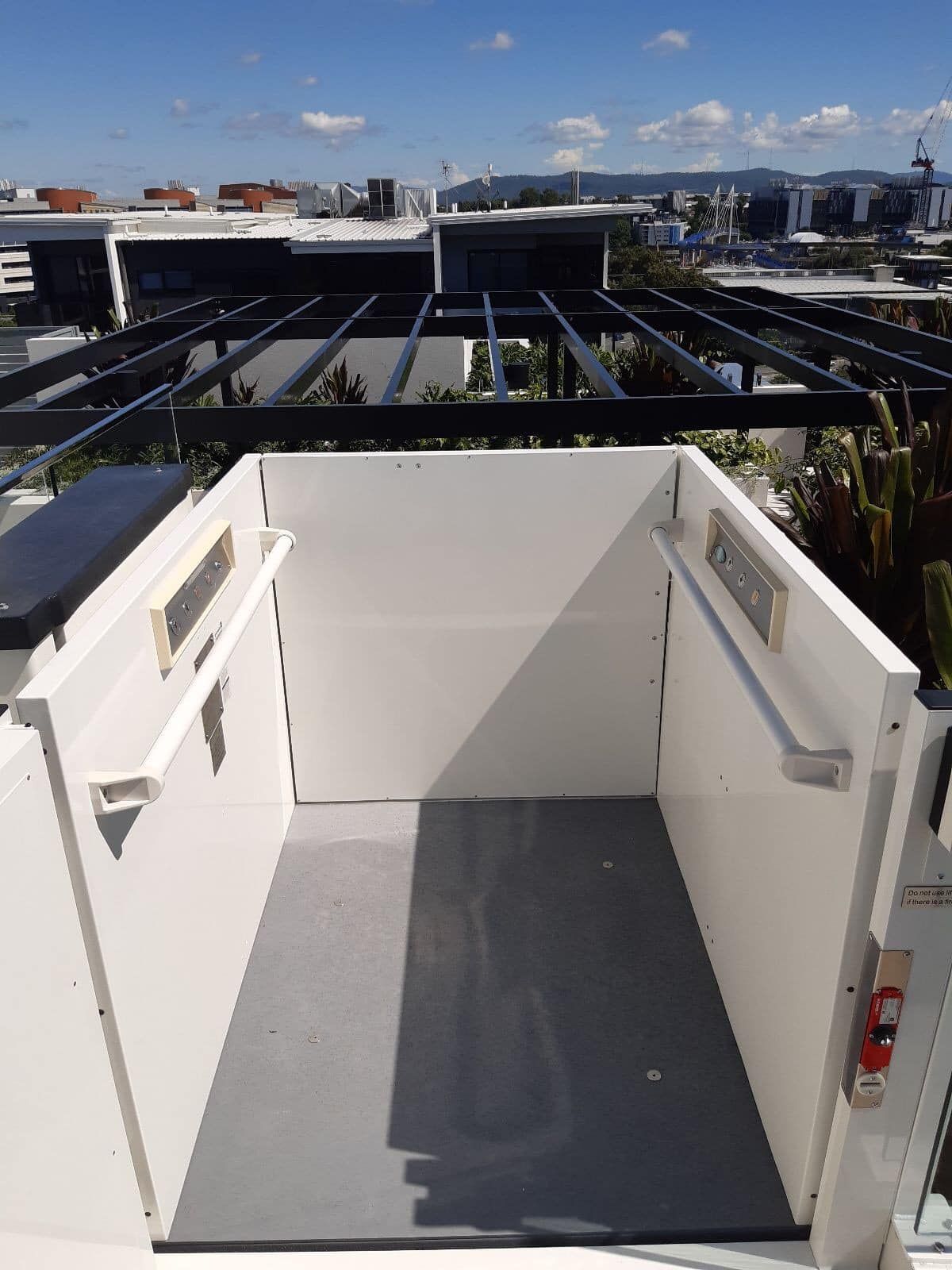 A White Elevator Is Sitting on Top of A Building — Master Lifts Cairns in Cairns, QLD