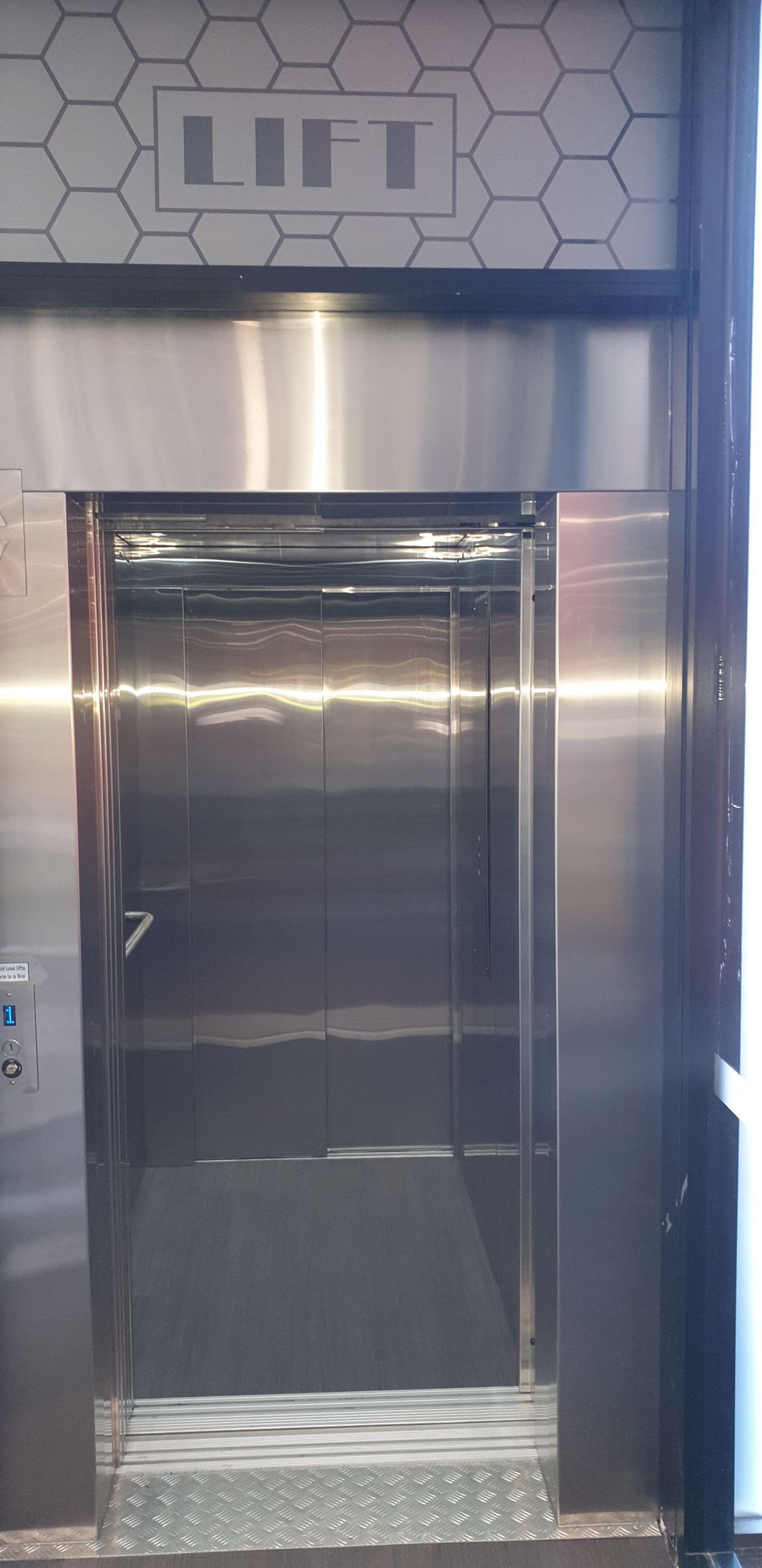 A Stainless Steel Elevator with A Honeycomb Pattern on The Wall — Master Lifts Cairns in Cairns, QLD
