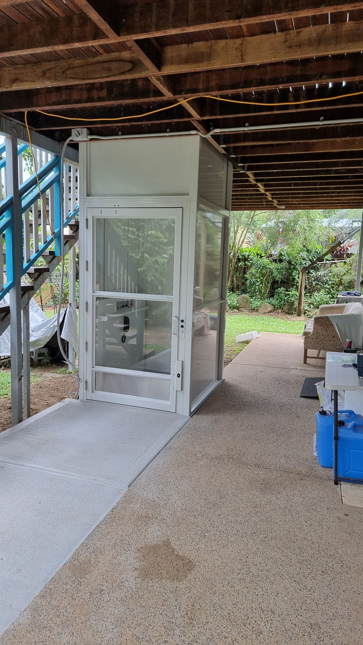 A White Elevator Is Sitting Under a Wooden Deck — Master Lifts Cairns in Cairns, QLD
