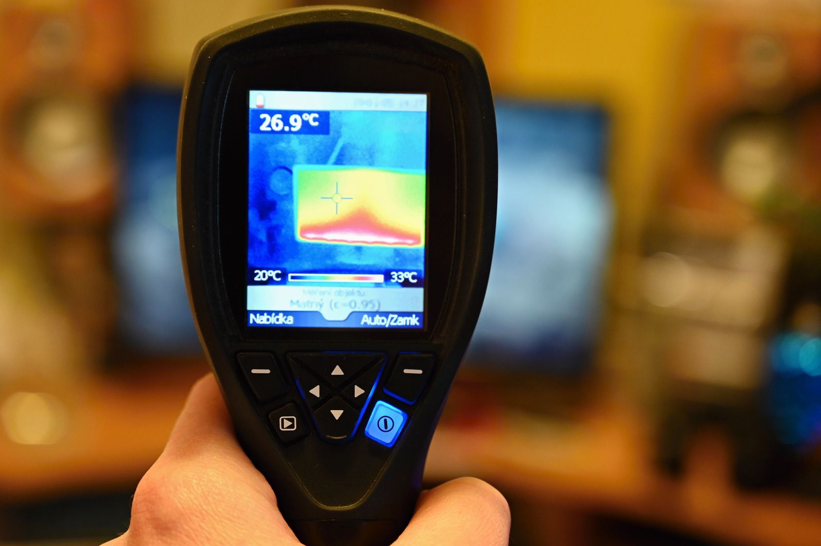 A person is holding a thermal camera that shows a temperature of 26.9 degrees celsius