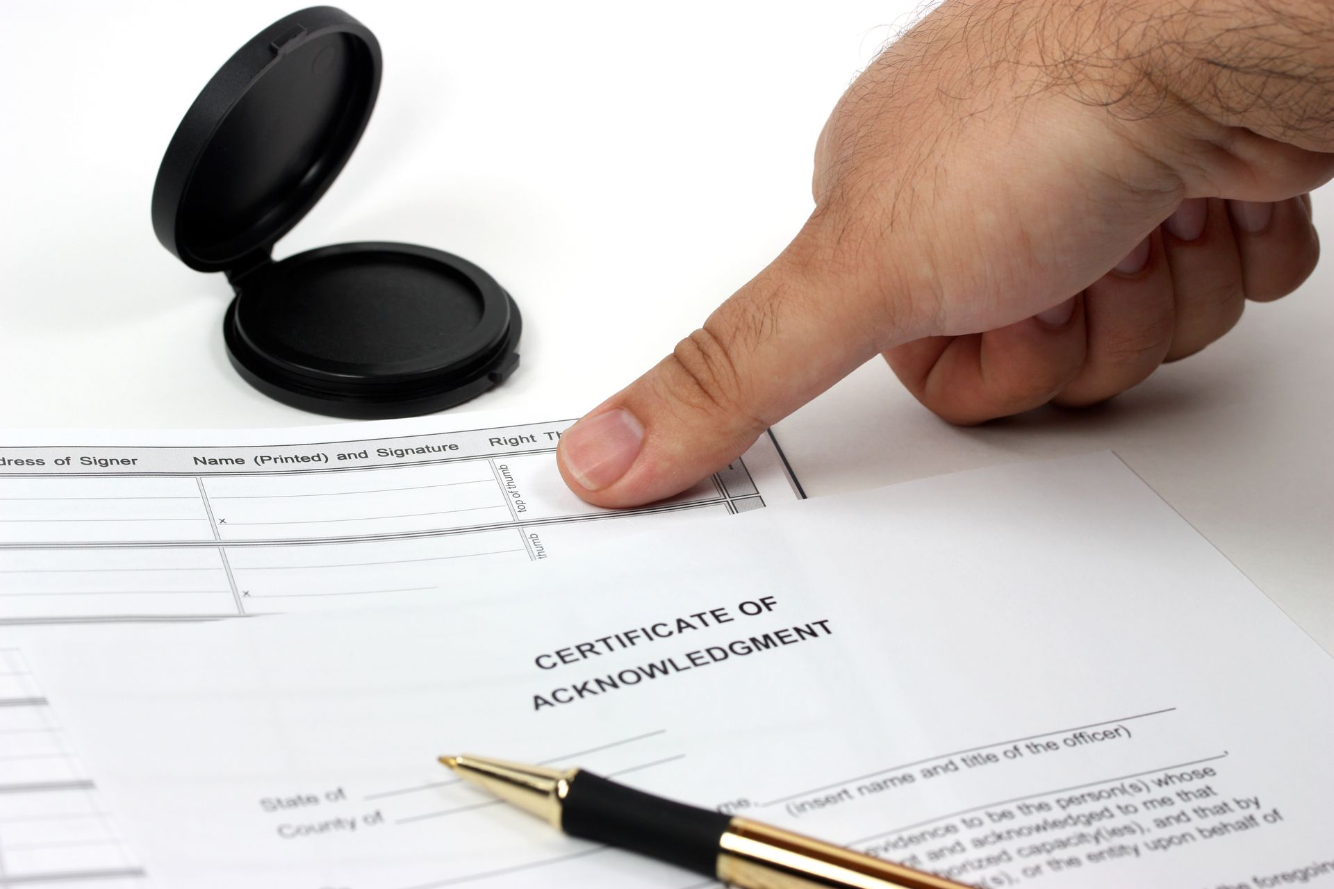 Hand stamping a certificate on a white desk with pen and ink pad