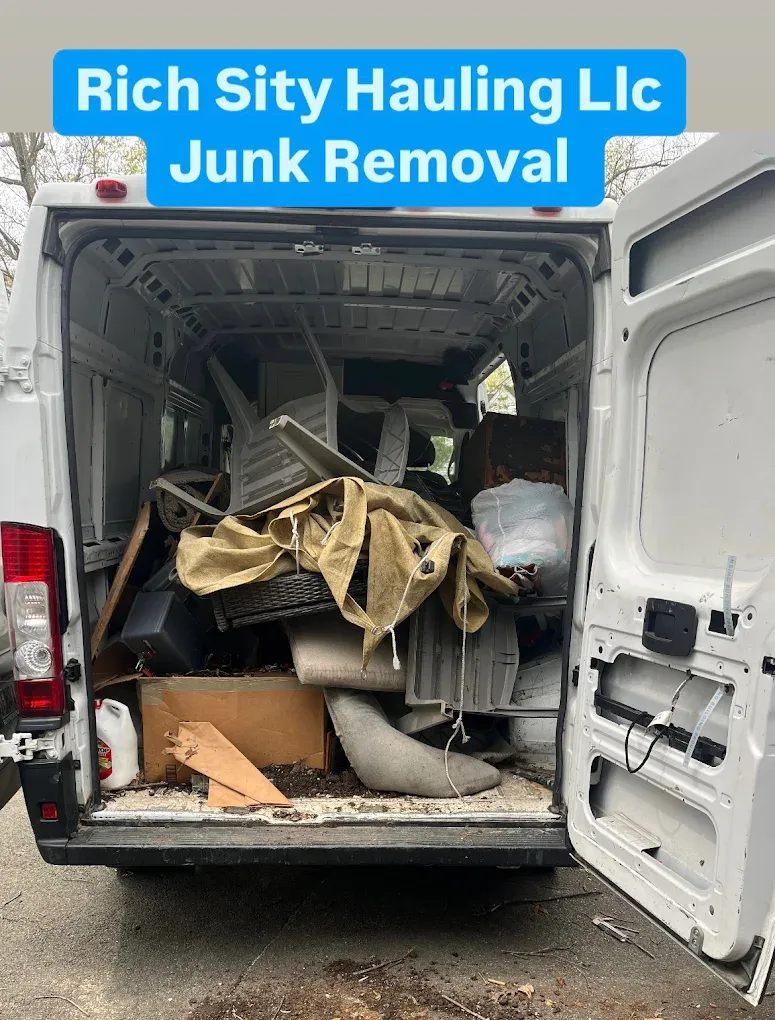 Open junk removal van packed with debris, labeled “Rich City Hauling LLC Junk Removal”
