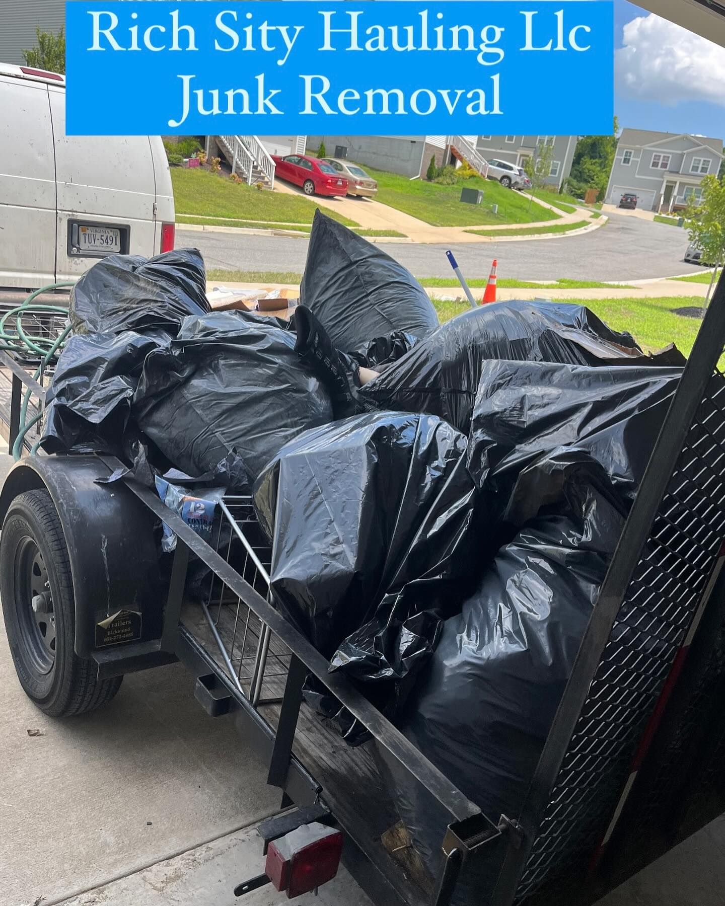 Trailer loaded with black trash bags for junk removal service outdoors