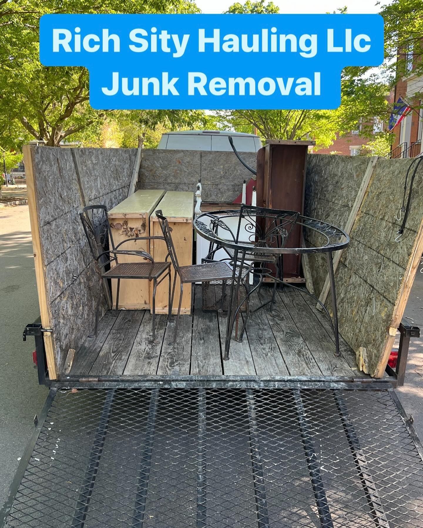 Junk removal trailer loaded with old furniture and debris under a Rich City Hauling LLC banner