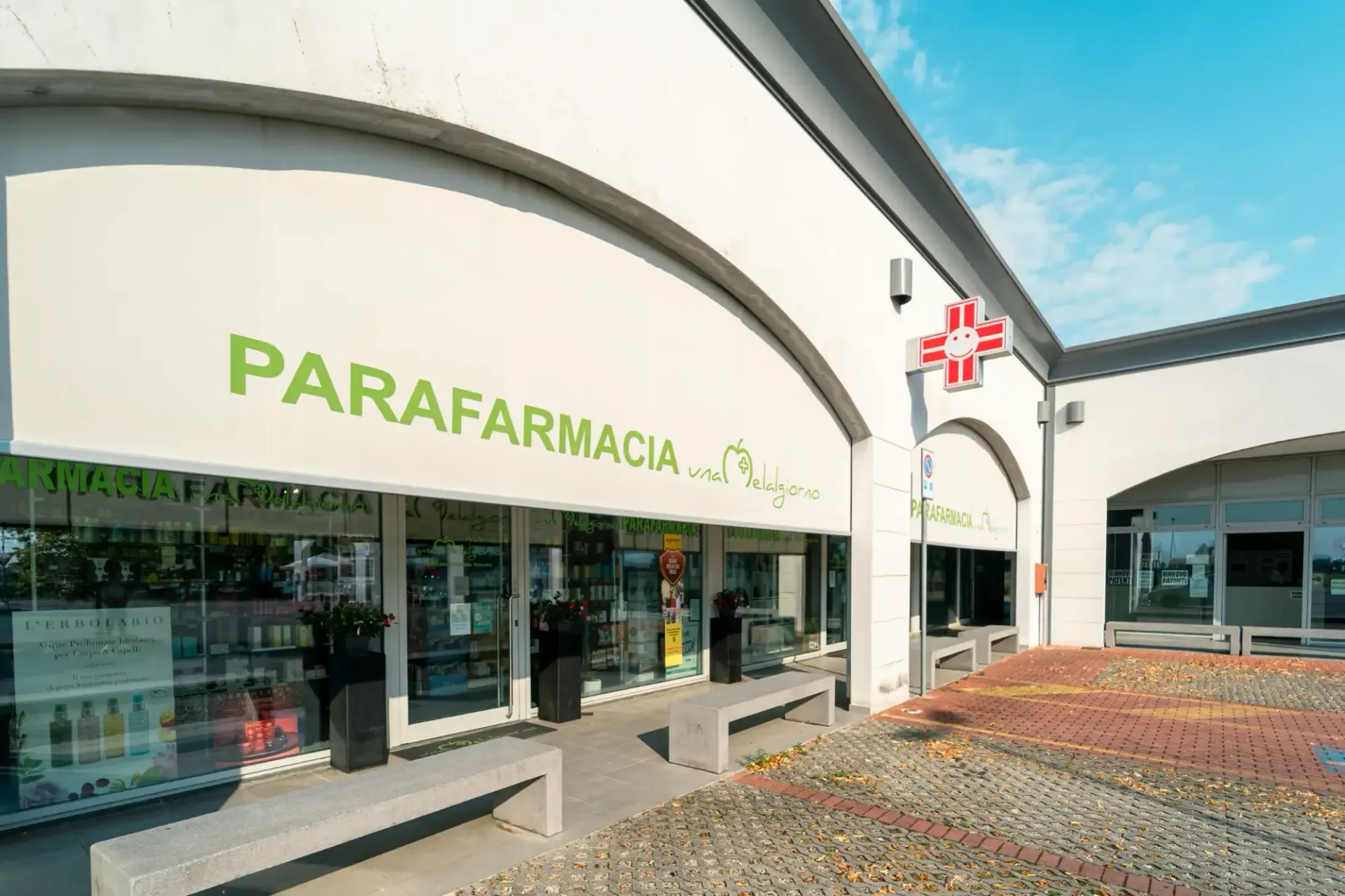 Vetrina di una farmacia con insegna verde