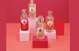 Quattro flaconi di profumo su blocchi rossi e rosa su sfondo rosso