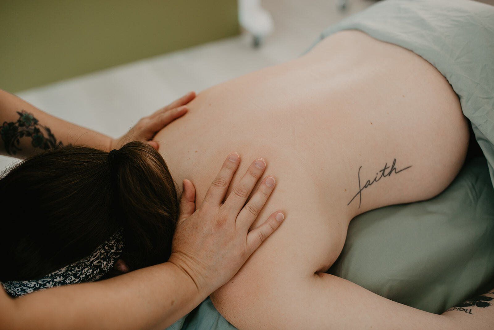 Pregnant woman lying face down getting a back massage