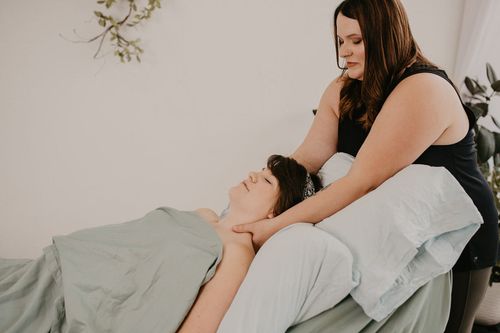 Pregnant woman lying face up getting a massage