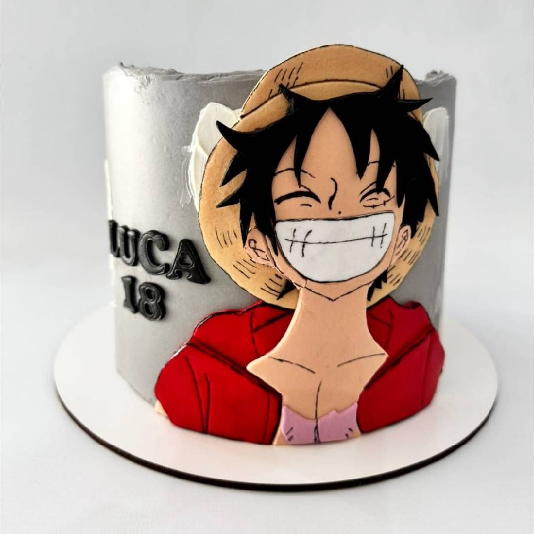 Tarta de One Piece con la cara de Luffy, sombrero de paja y chaqueta roja sobre una base blanca.