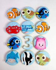 Varias pegatinas redondas de colores con motivos de peces y criaturas marinas dispuestas alrededor de un número 3 plateado.