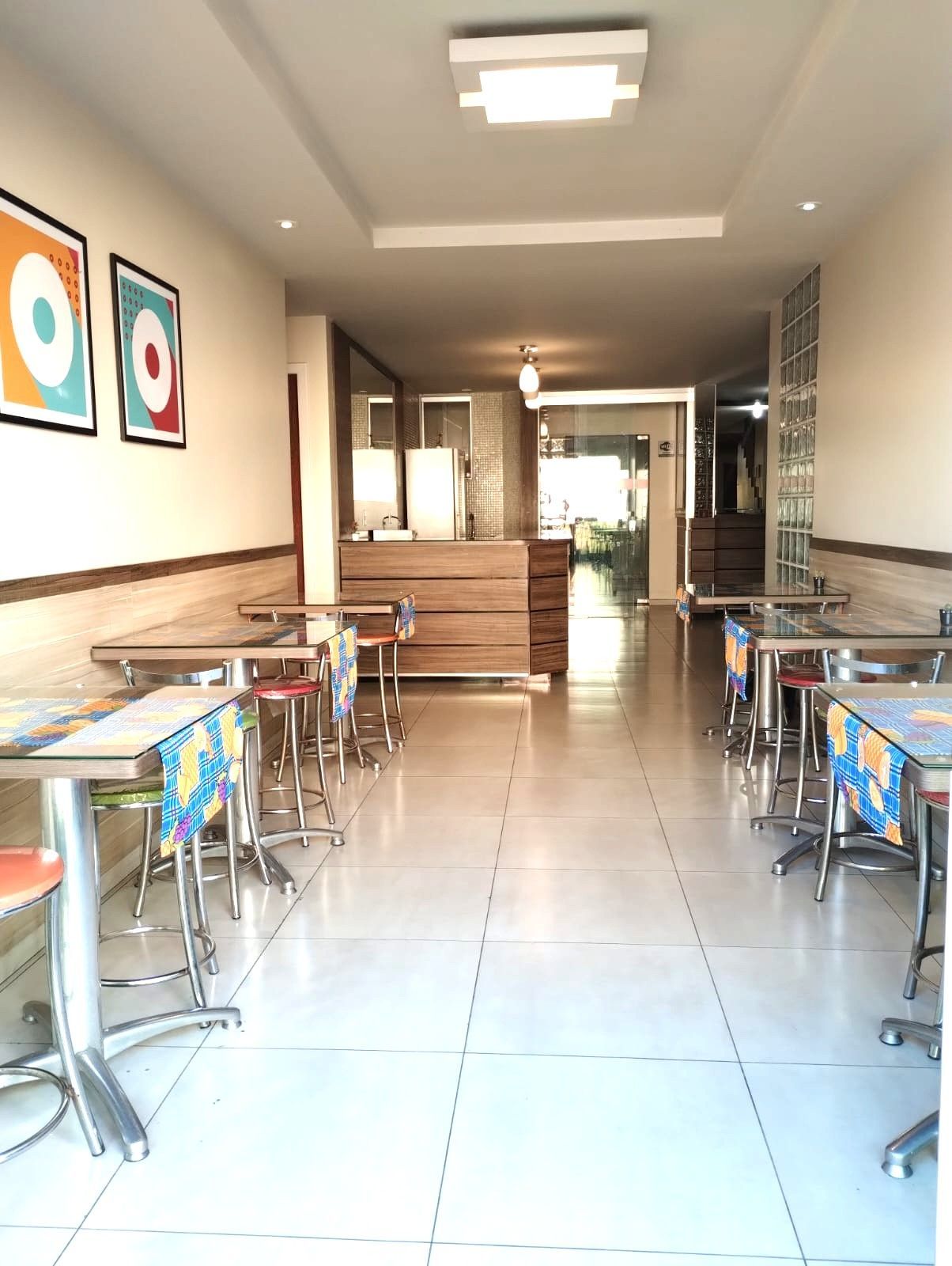 Um longo corredor com mesas e cadeiras em um restaurante
