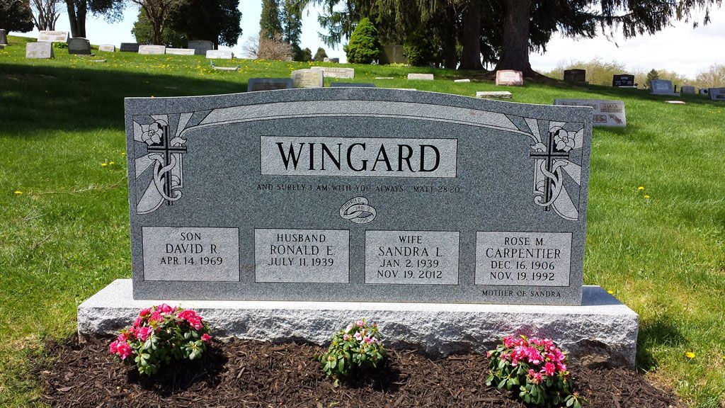 Wingard family gravestone with flower pots in a cemetery, front view on a sunny day
