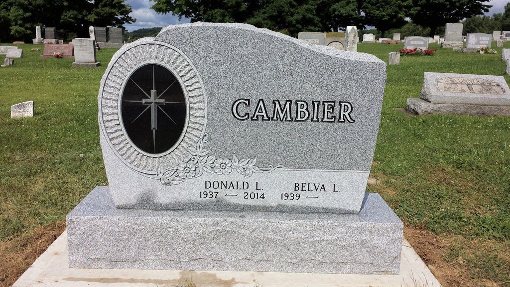 Gray granite gravestone with oval portrait inset and “CANDLER” engraved, in a cemetery lawn.