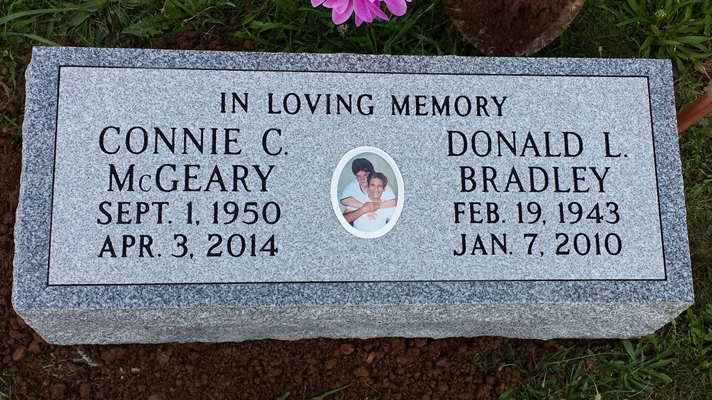 Granite memorial plaque with oval photo, inscribed “In loving memory” for Connie C. McGarry and Donald L. Bradley.