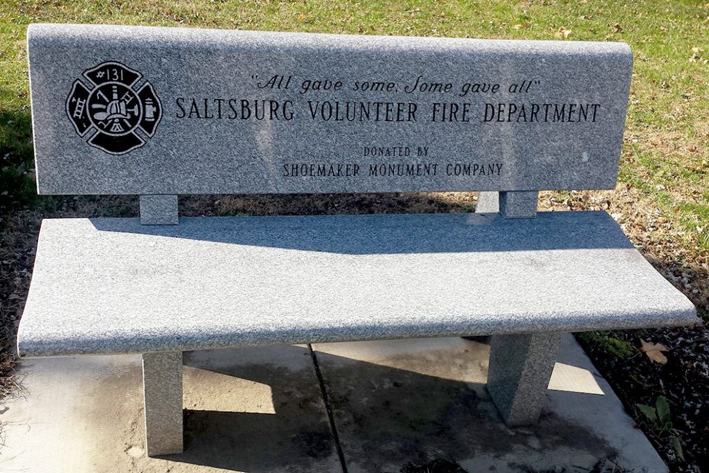 Stone memorial bench engraved for Silsbee volunteer fire department, set on grass outdoors