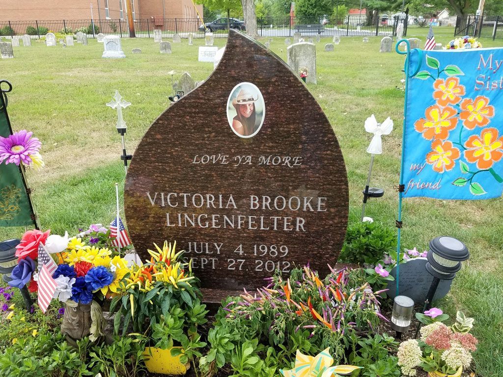 Gravestone with flowers in a cemetery, marked Victoria Brooke Lingentler with dates below.
