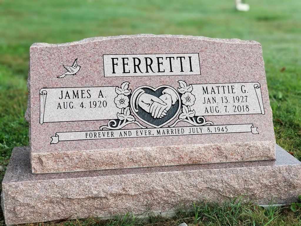 FERRETTI gravestone with engraved name plaques in a grassy cemetery
