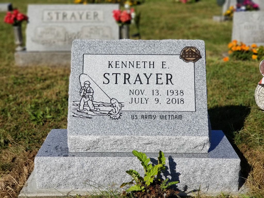 Kenneth F. Strayer gravestone in a cemetery with flowers and grass