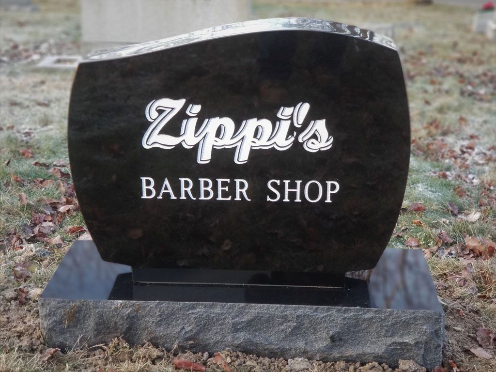 Zippi's Barber Shop sign on a black stone monument outdoors