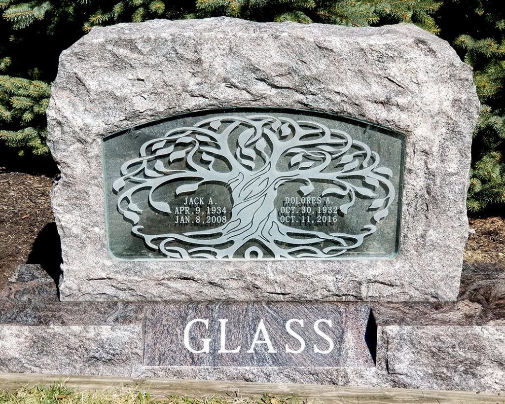 Stone monument with engraved glass panel and the word “GLASS” on the base.