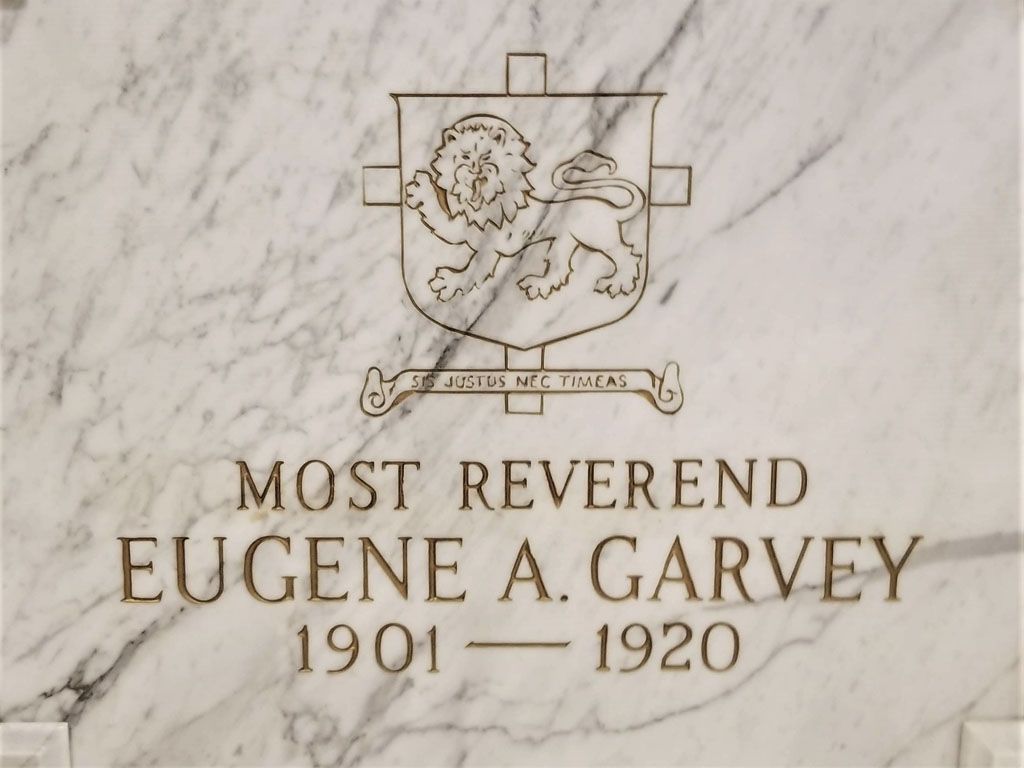 Marble memorial plaque for Most Reverend Eugene A. Garvey, 1901–1920, with engraved coat of arms.