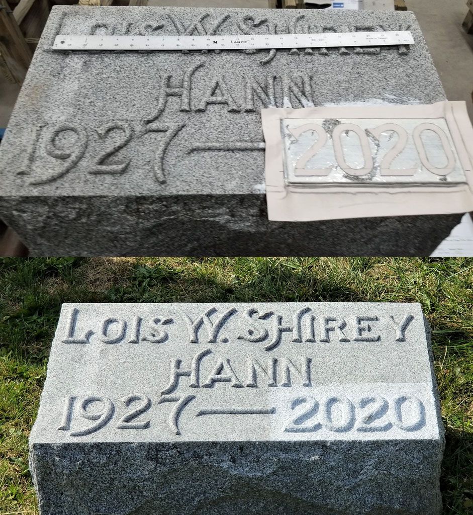 Two gray granite grave markers with engraved names and dates, one showing a temporary plaque on top