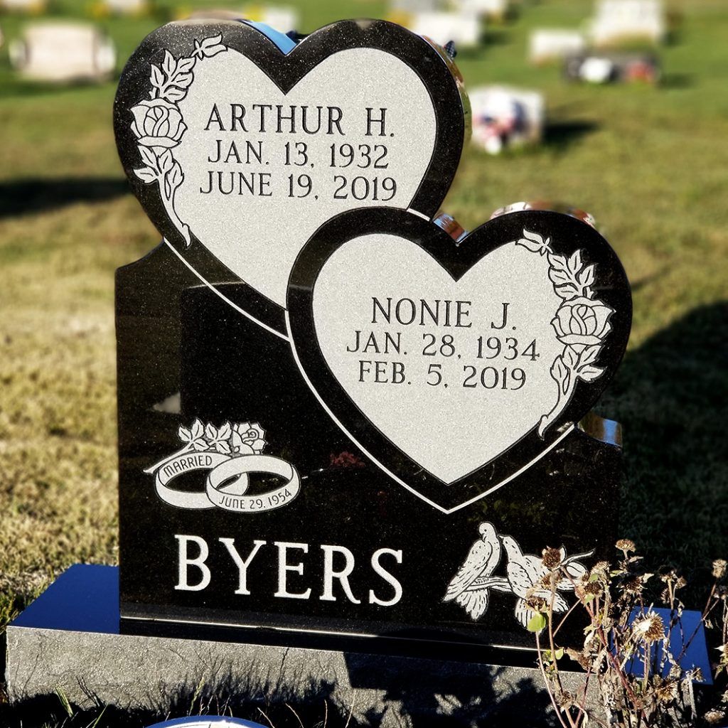 Byers memorial headstone with two heart plaques and white floral engraving in a cemetery.