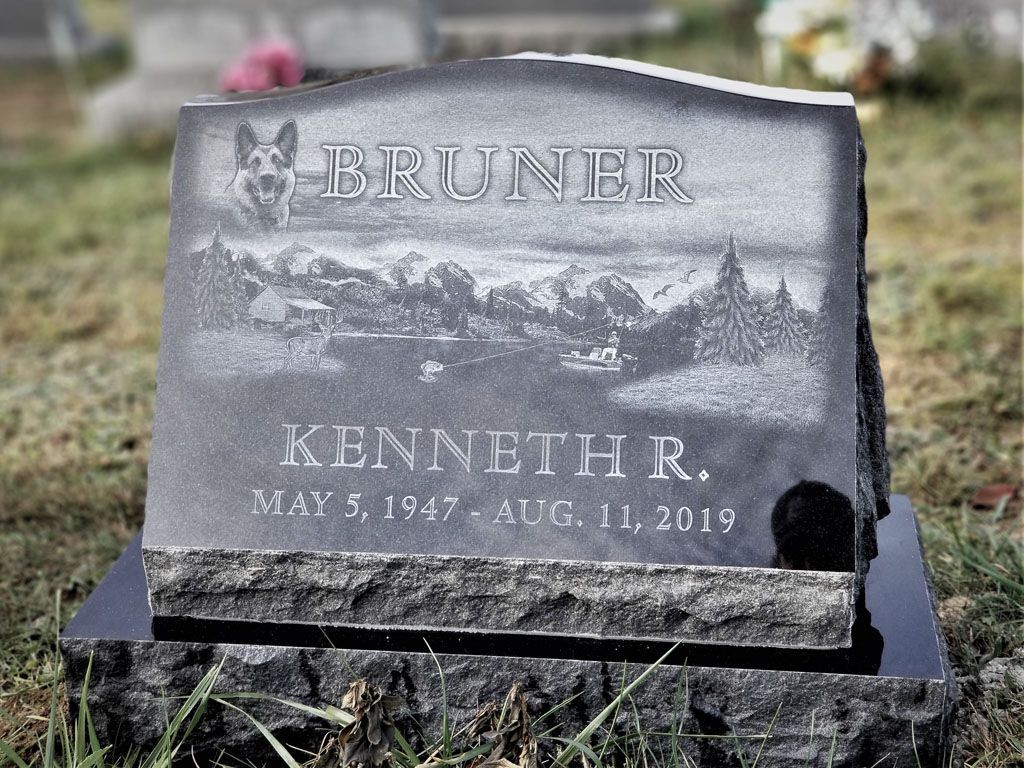 Gray gravestone with engraved name Kenneth R. Bruner in a cemetery