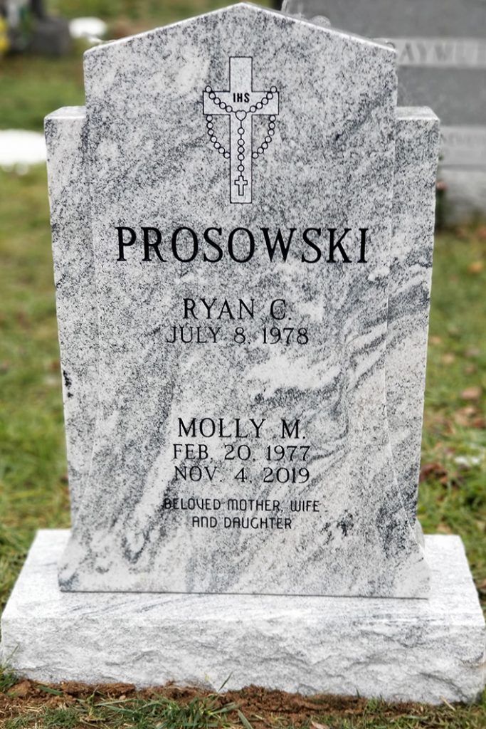 Gravestone with cross for the Prosowski family, marked Ryan and Molly, in a cemetery.