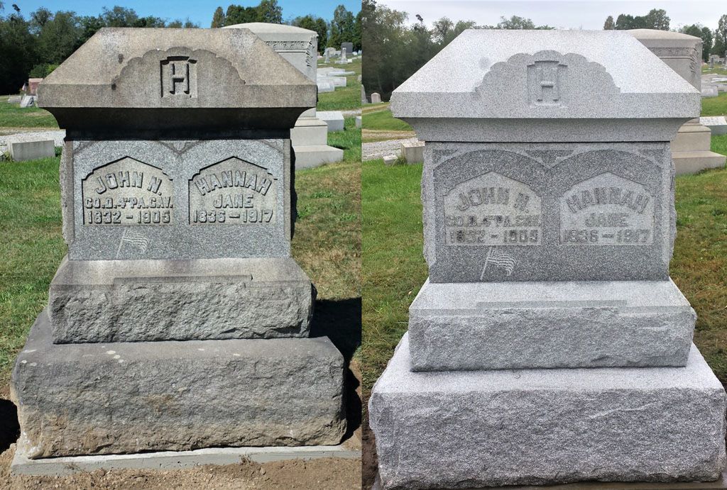 Two granite gravestones side by side in a grassy cemetery, one dark and one light-colored.