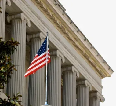 An american flag is flying in front of a building
