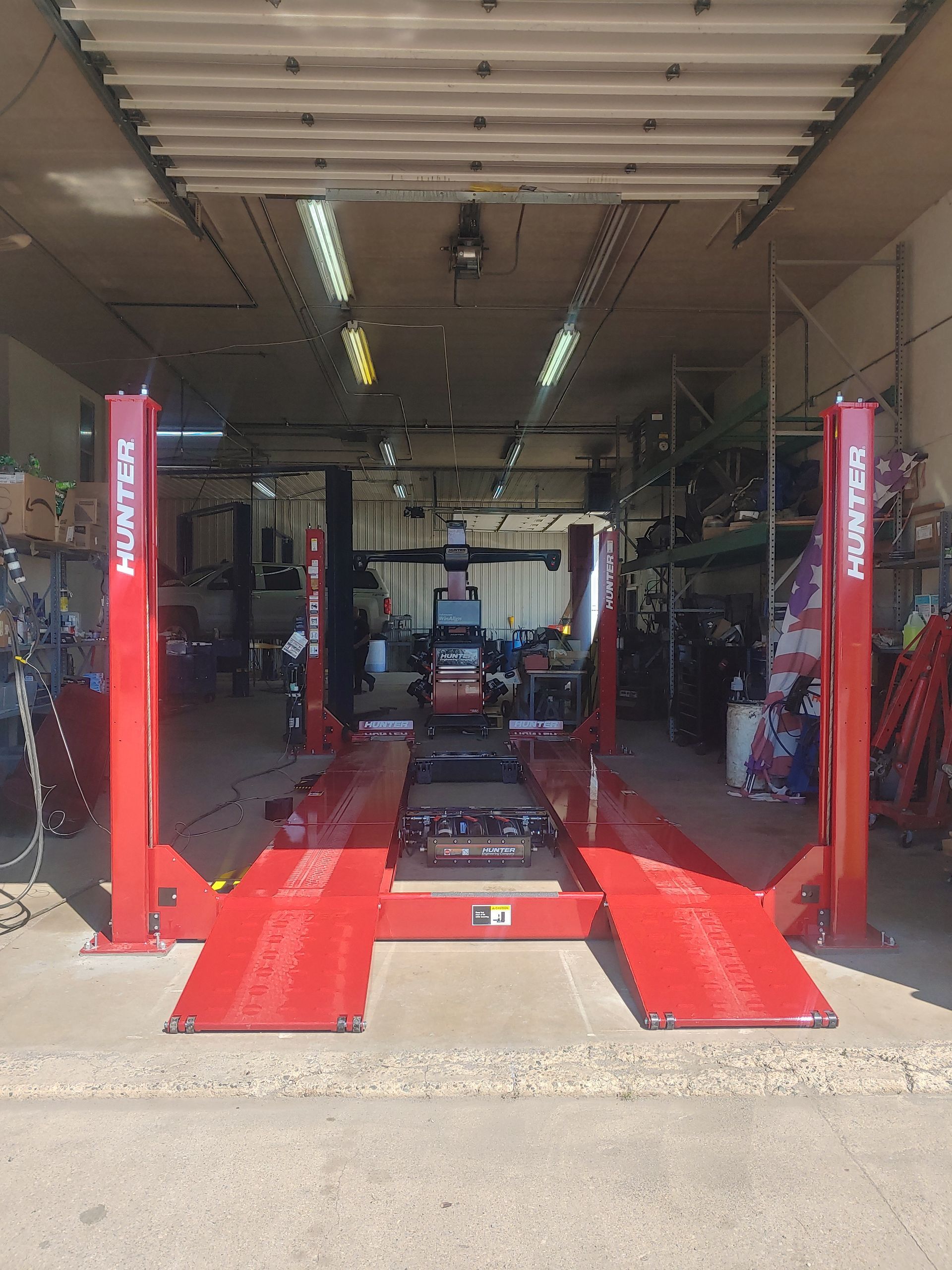 Red Hunter car lift in a garage with a car. | Flagg's Automotive