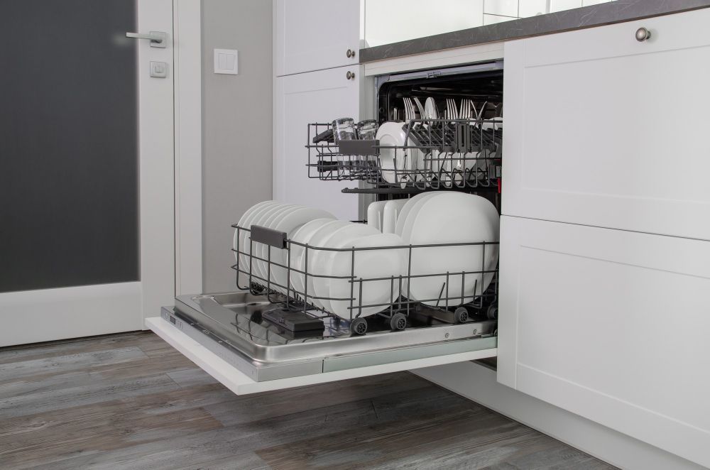 A Dishwasher Is Filled With Plates And Utensils In A Kitchen