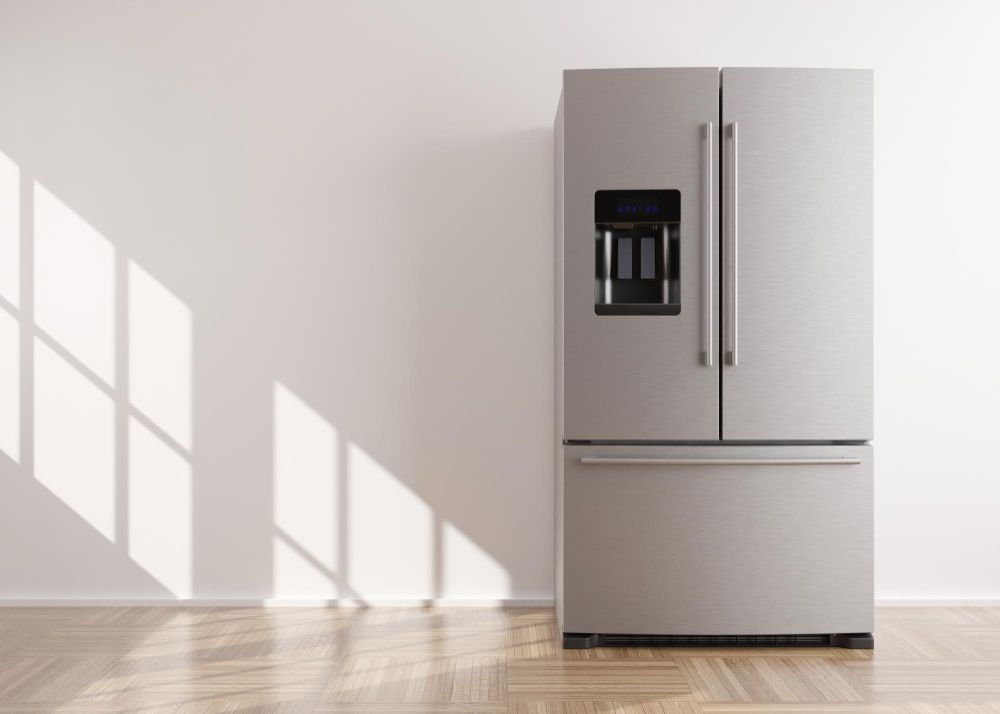A Stainless Steel Refrigerator Is Sitting In An Empty Room Next To A Window