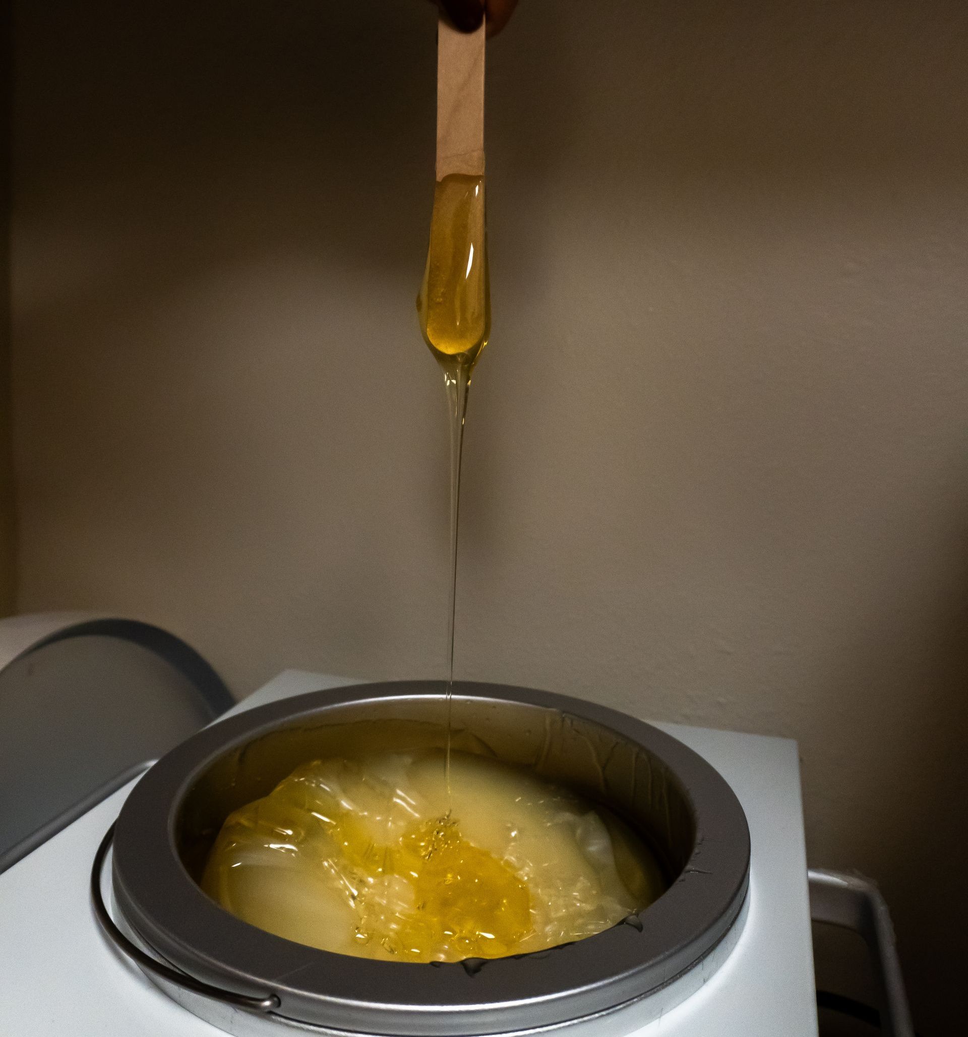 A person is pouring wax into a wax warmer