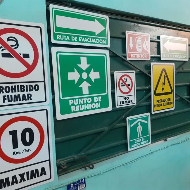 Varios carteles en una pared, incluido uno que dice punto de reunión.