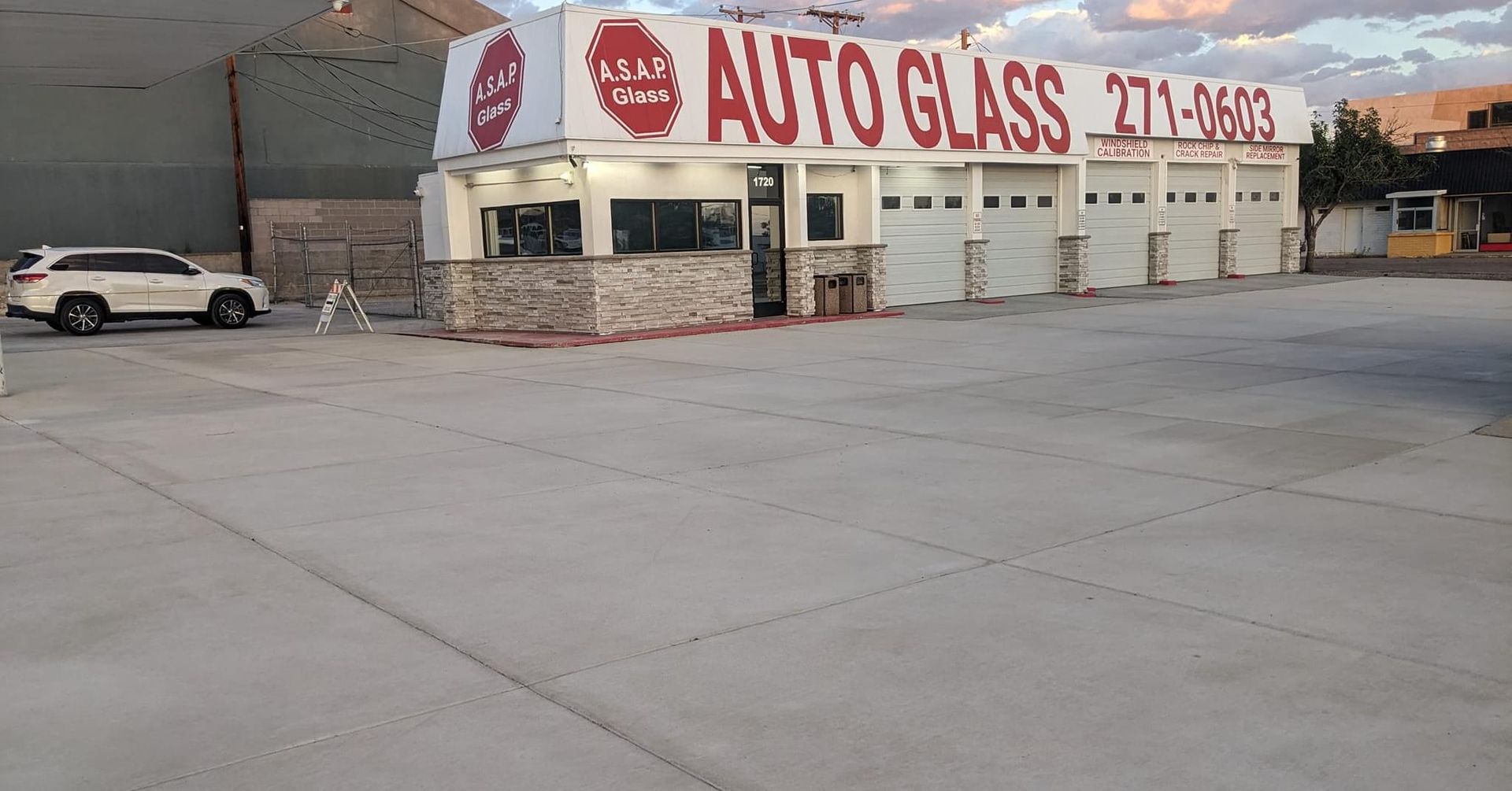 A white car is parked in front of an auto glass store — Auto Glass in Albuquerque, NM A white car is parked in front of an auto glass store