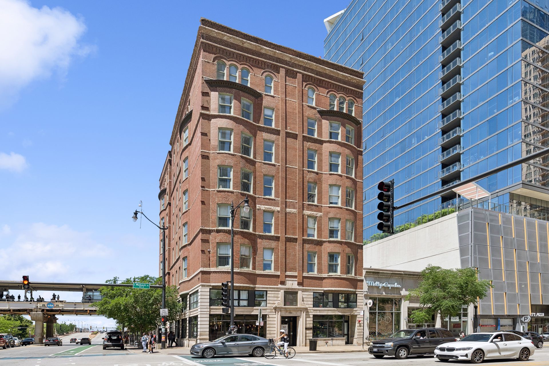 A large brick building is sitting on the corner of a city street.