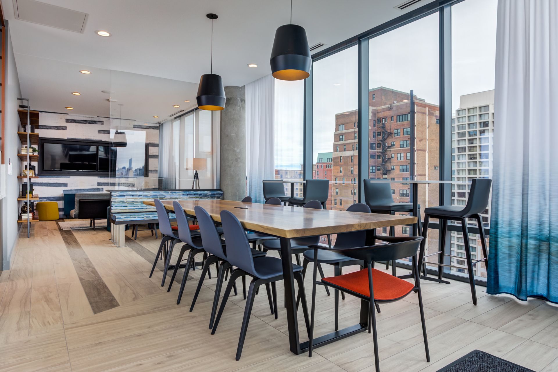 A large room with a table and chairs and a lot of windows.