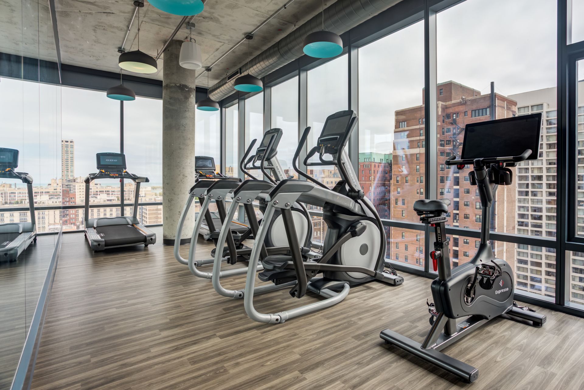 A gym with a lot of windows and exercise equipment.