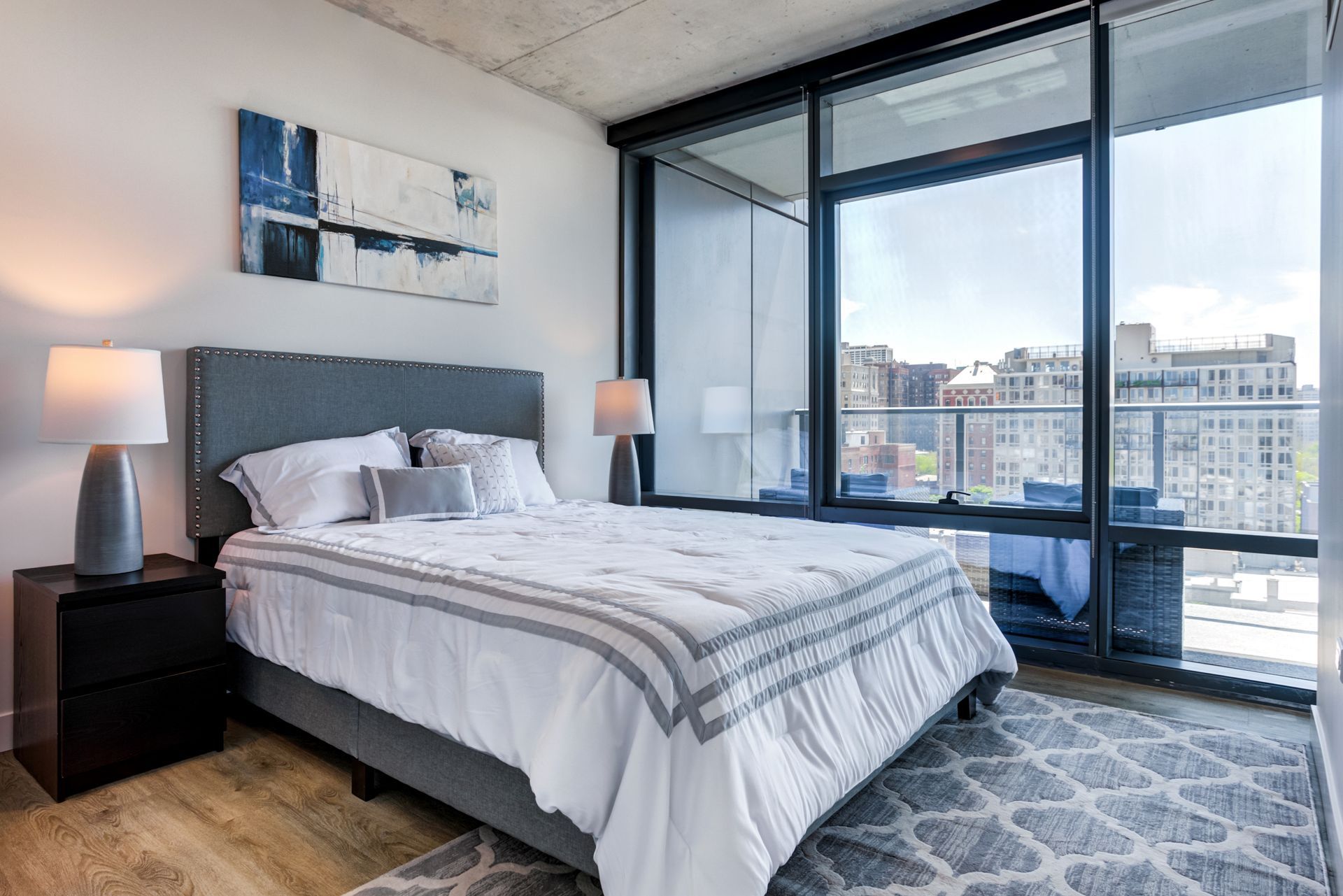 A bedroom with a large bed and a large window.