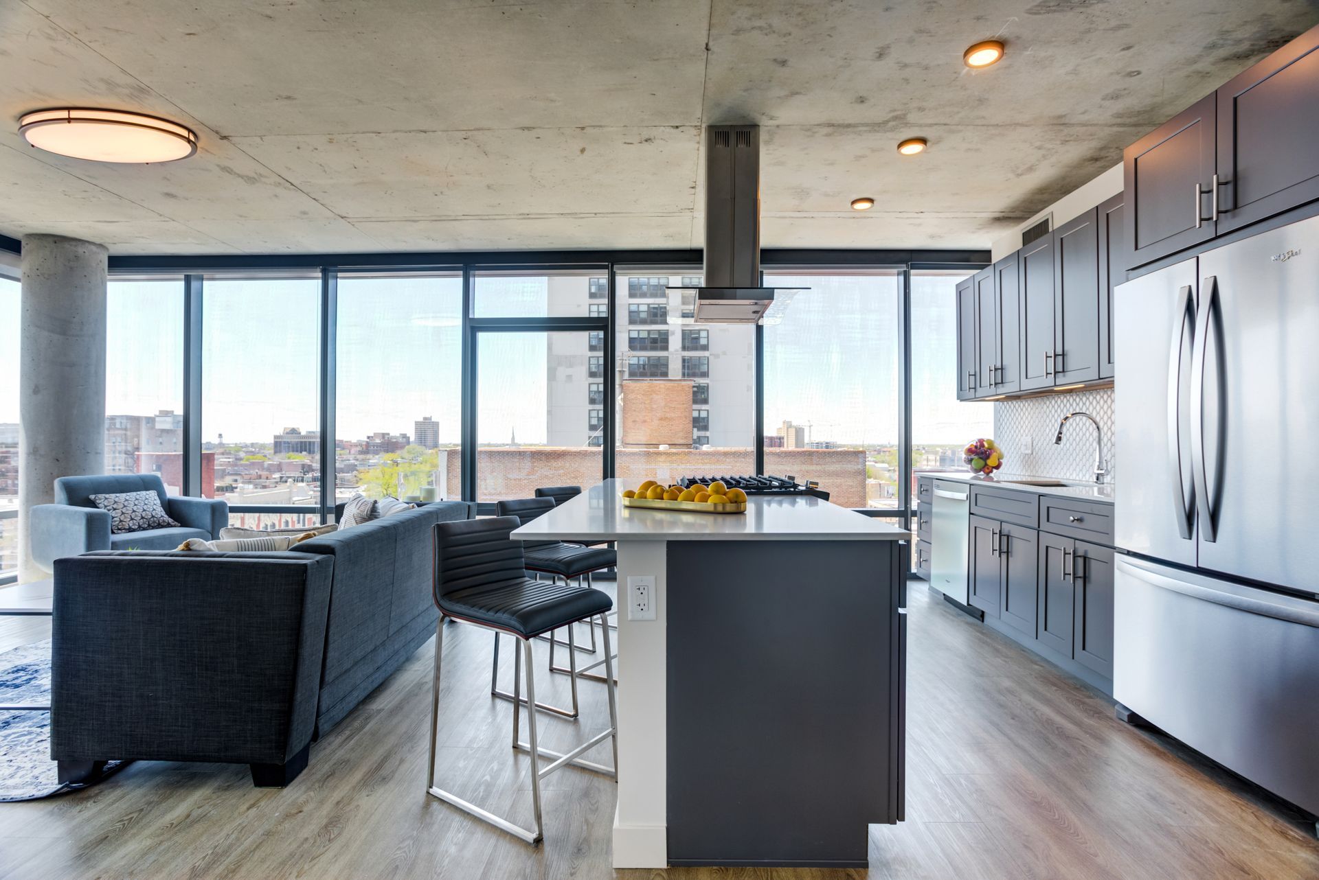 A kitchen with stainless steel appliances and a large island in the middle of the room.