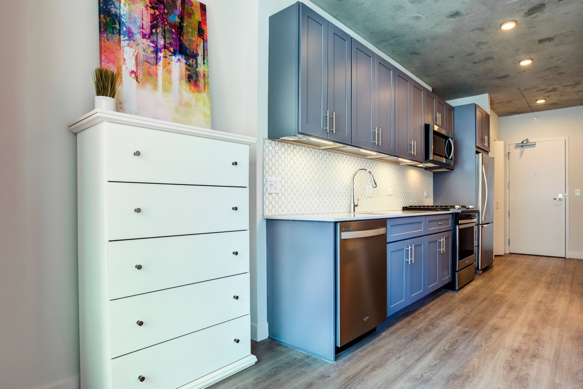 A kitchen with blue cabinets and stainless steel appliances.