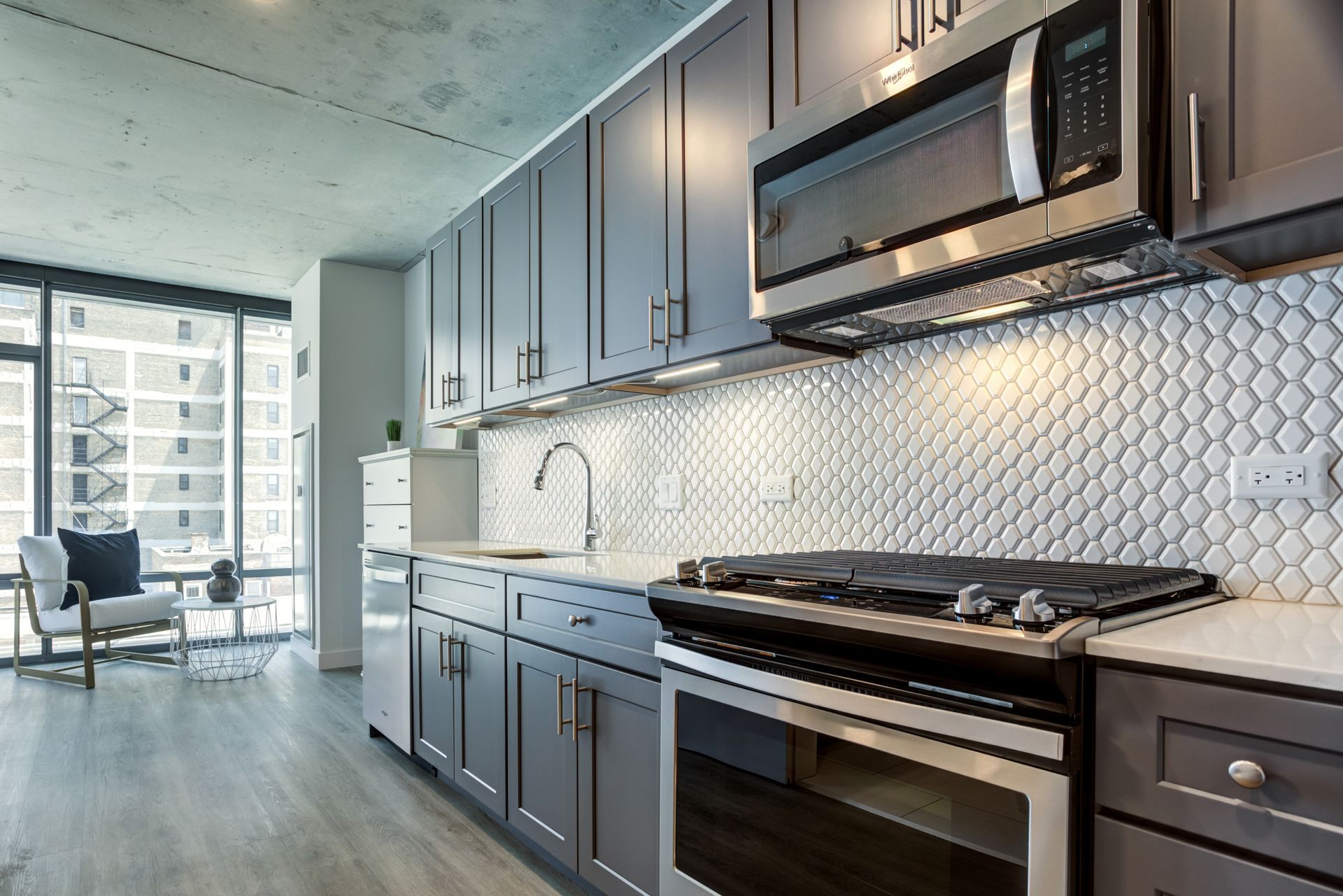 A kitchen with stainless steel appliances and gray cabinets
