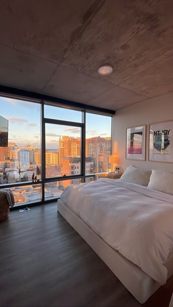 A bedroom with a large bed and a large window.